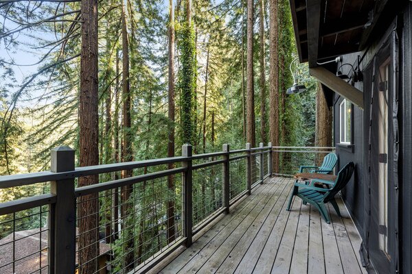 Multiple decks and outdoor areas overlook the hillside surrounding the home, including this one located off the kitchen on the main level.