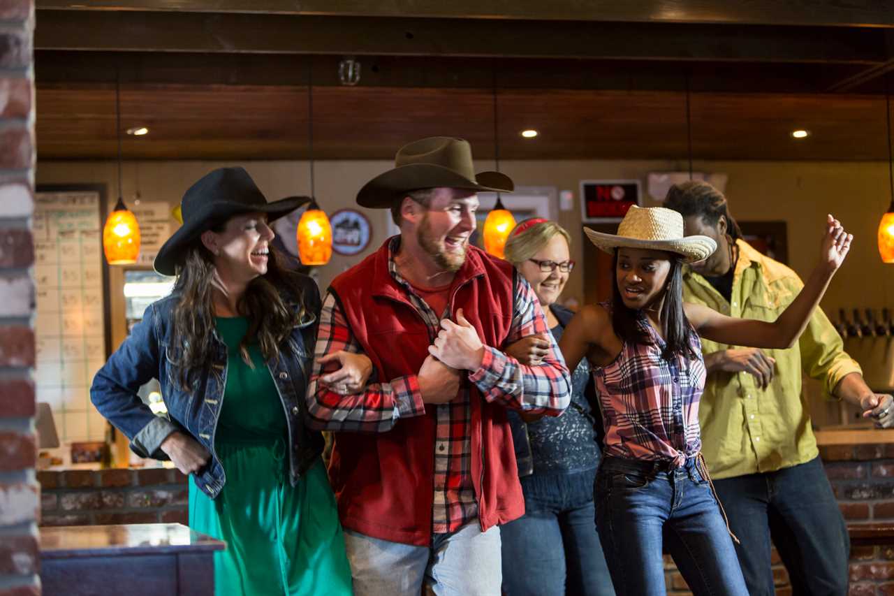 A group of friends dancing and having fun in a country bar