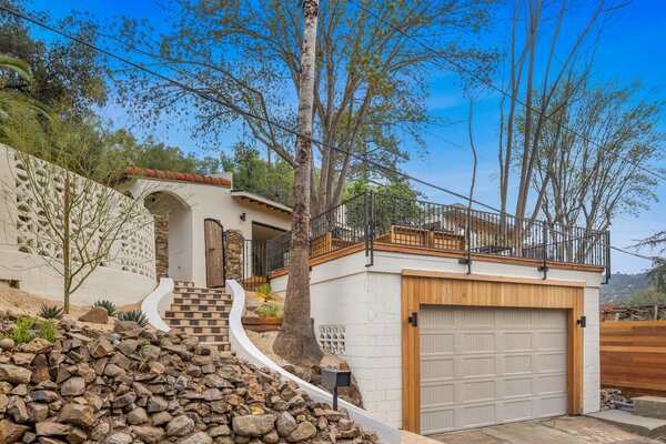 Upon arrival, a curved staircase leads to the main entrance. Above the two-car garage is a large terrace which has been carefully built around a soaring tree that offers ample shade.