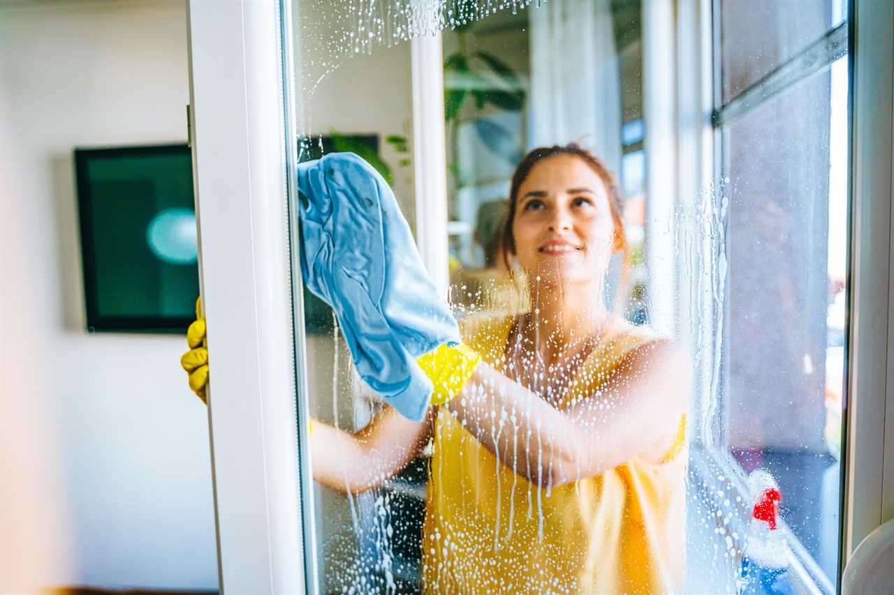 Glass cleaner using a cleaning solution to wipe off stains on a mirror with a microfiber cloth