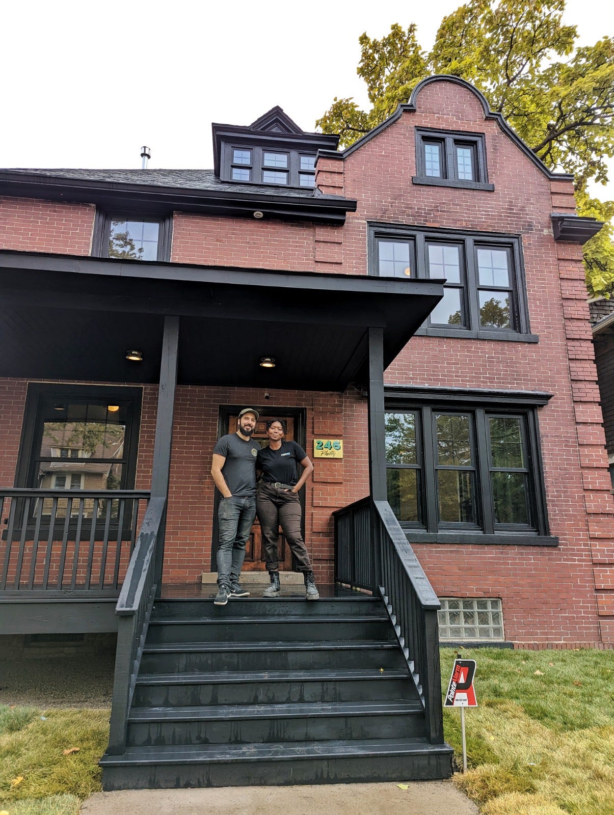 Kyle Dubay and Bo Shepherd in front of renovated home.