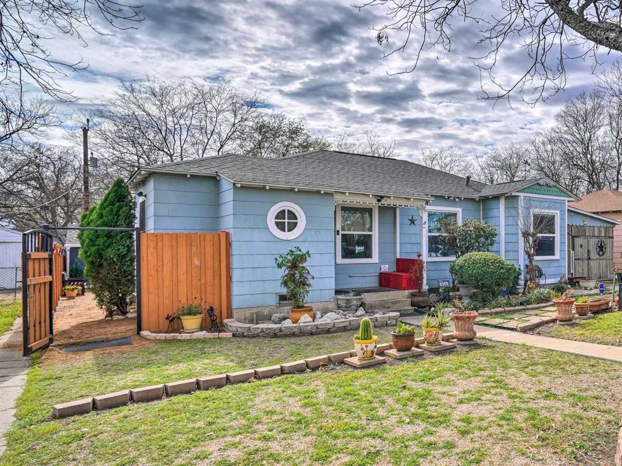 A wooden gate to the left of a blue house