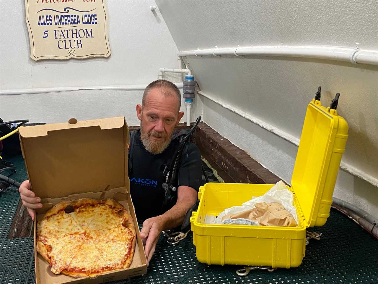 Thane Milhoan, the habitat operations manager, delivers pizza to the Jules' Undersea Lodge. Pizza