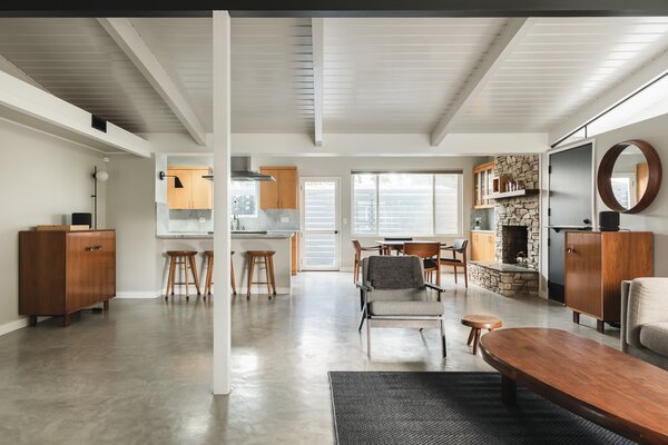 Inside, finished concrete flooring connects the main living areas, all of which are bathed in sunshine thanks to skylights, glass doors, and elongated clerestory windows.