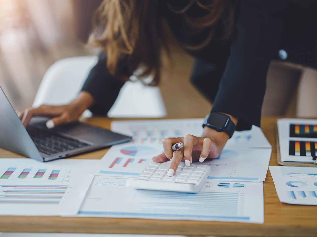 business woman hands using a calculator to check company finances and earnings and budget