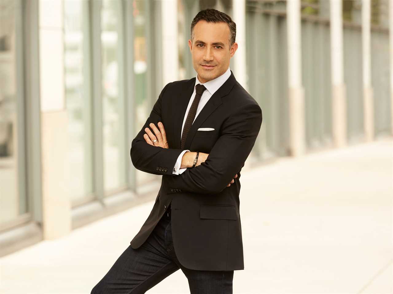 headshot of Randy Baruh with his arms crossed in a black suit