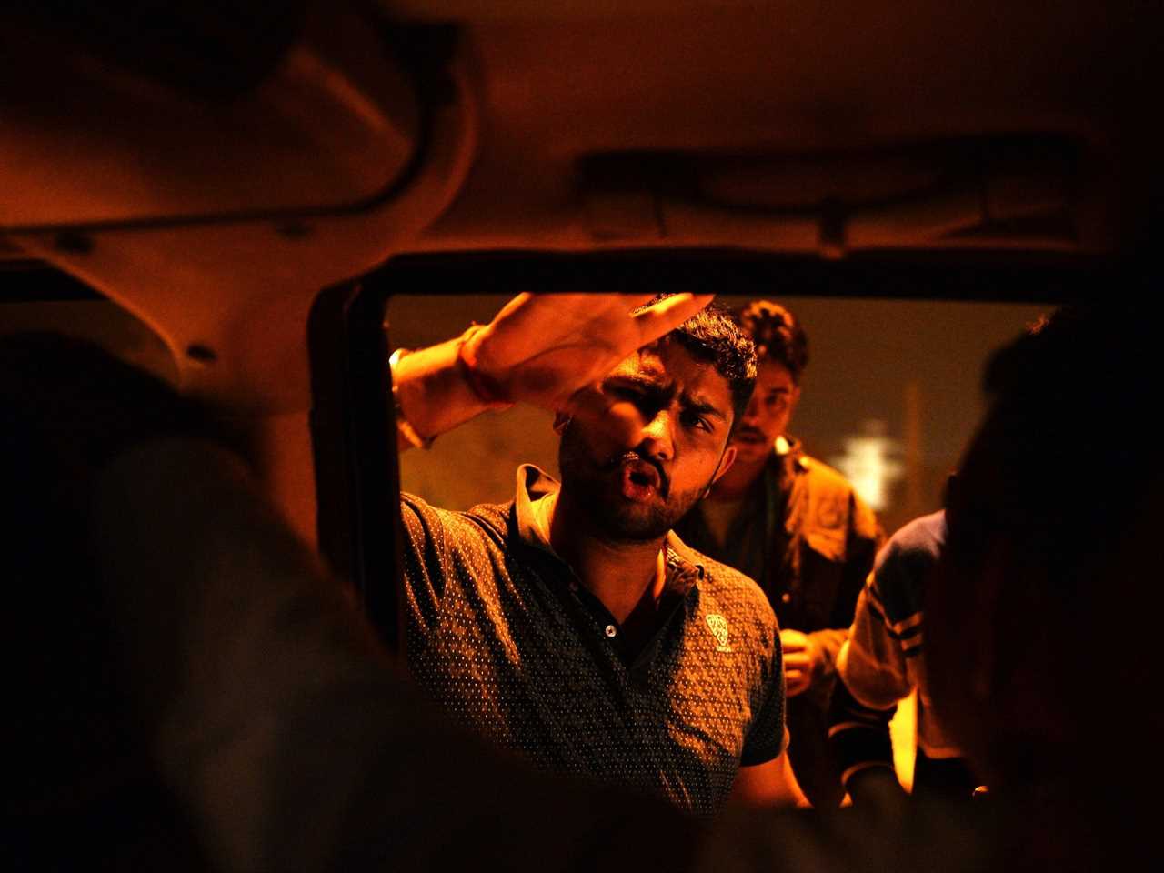 A volunteer for a cow vigilante group that enforced a ban on beef slaughtering has his hand up on the car window and explains the ban to a driver in India in 2015.