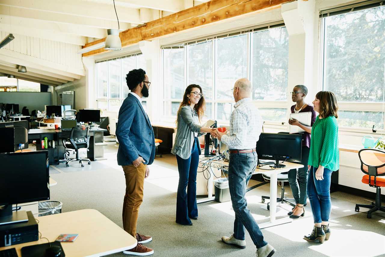 Businesswoman shaking hands with client before meeting in start up office.