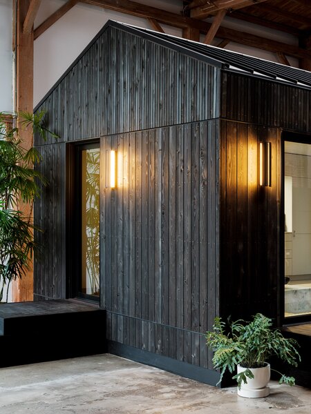 The vertical cedar slats create a sophisticated exterior that echo the outdoor sconces designed by Brendan Ravenhill that provide adjustable, dimmable light.