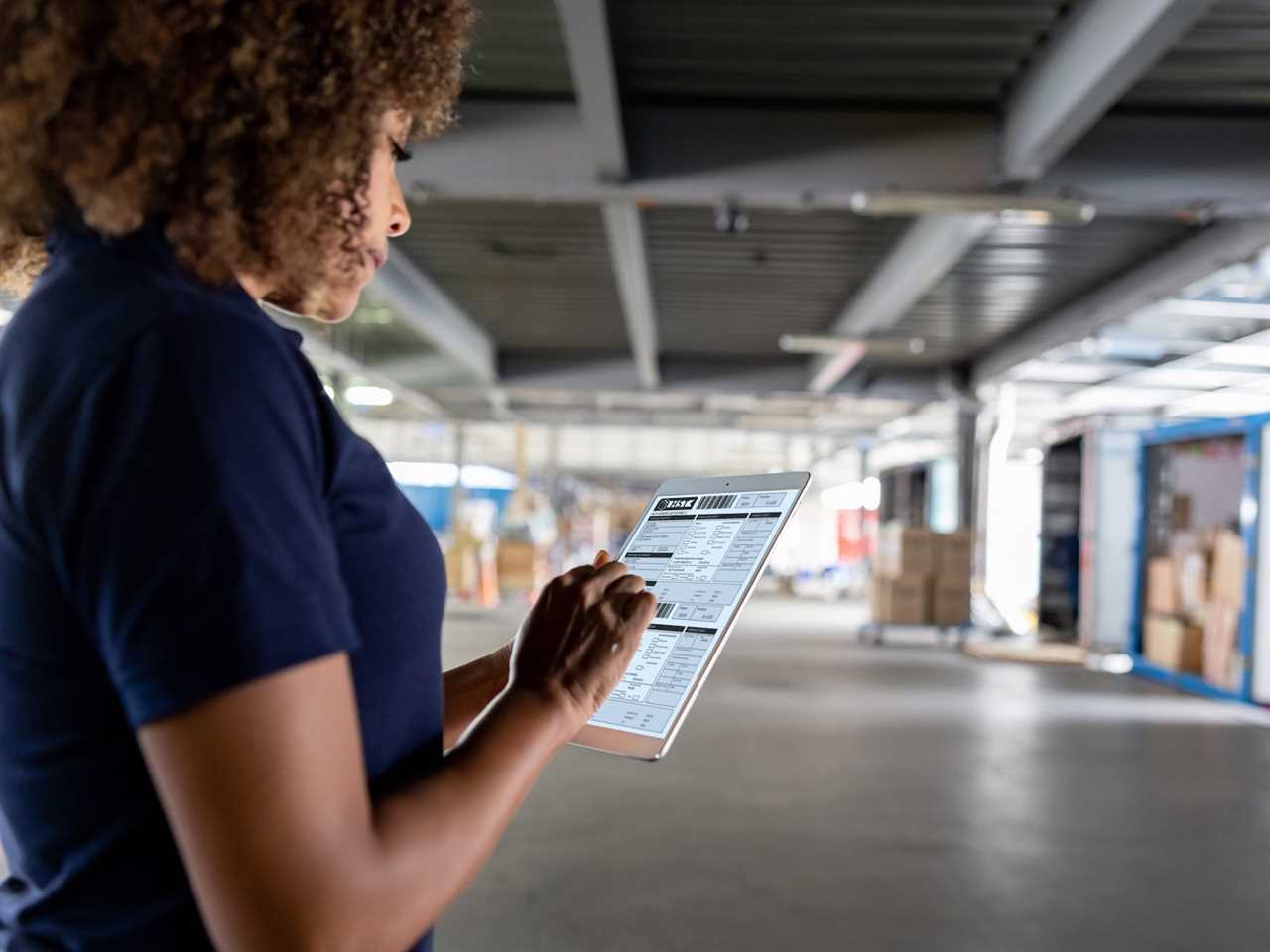 A worker working at a commercial dock and organizing the shipments of cargo in trucks