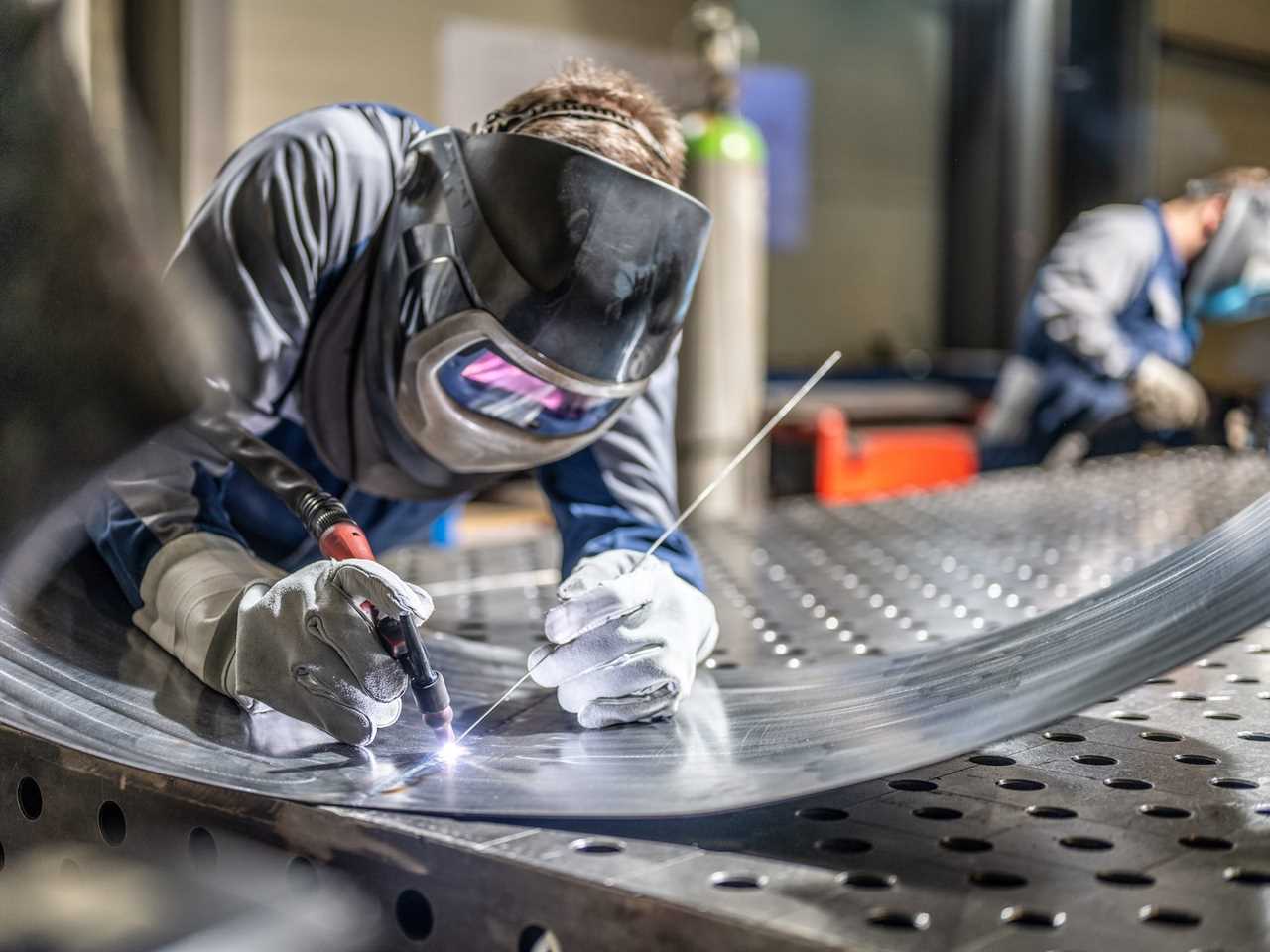 Person welding a piece of sheet metal