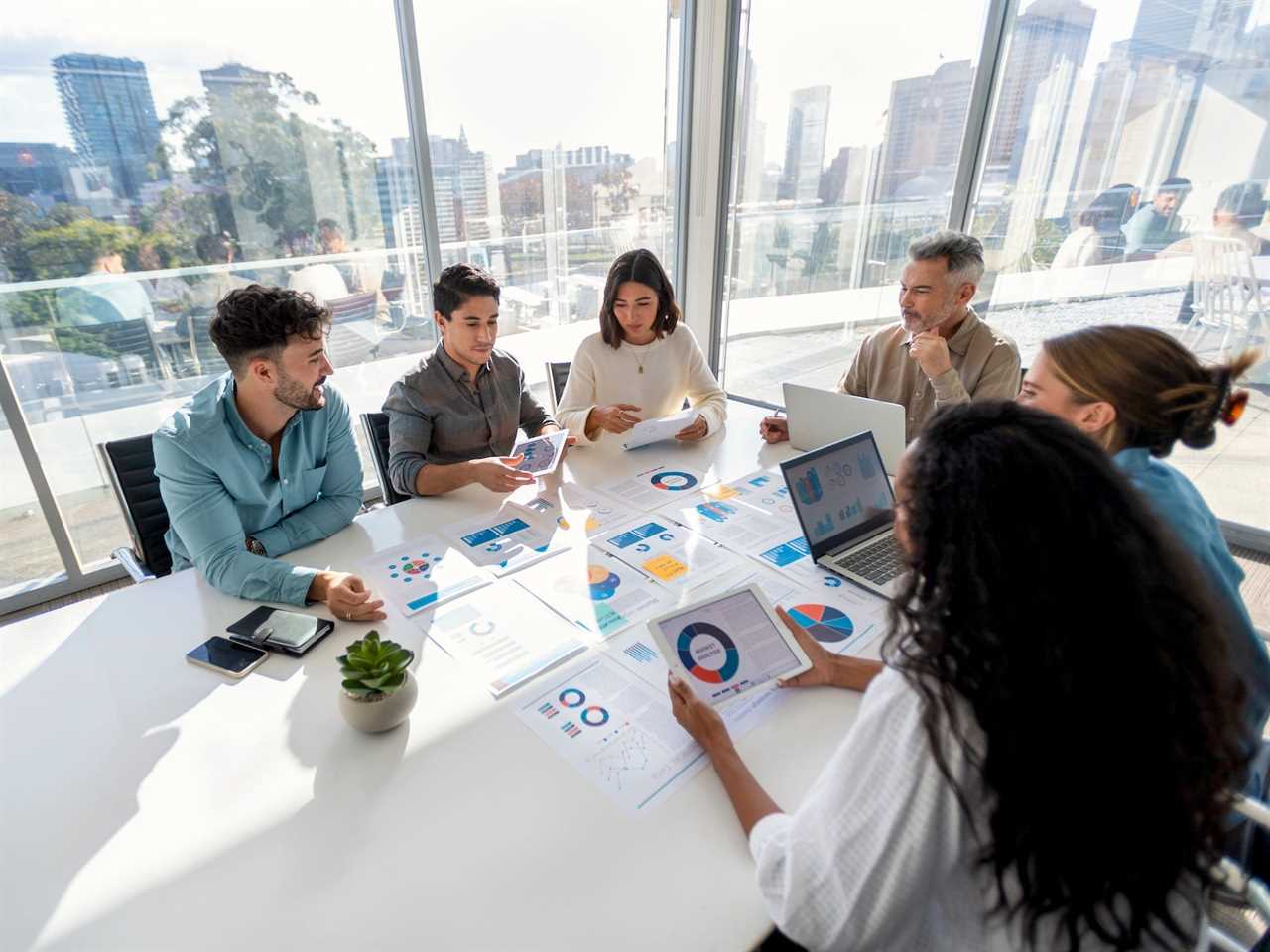 A group of workers sitting at a table in an office