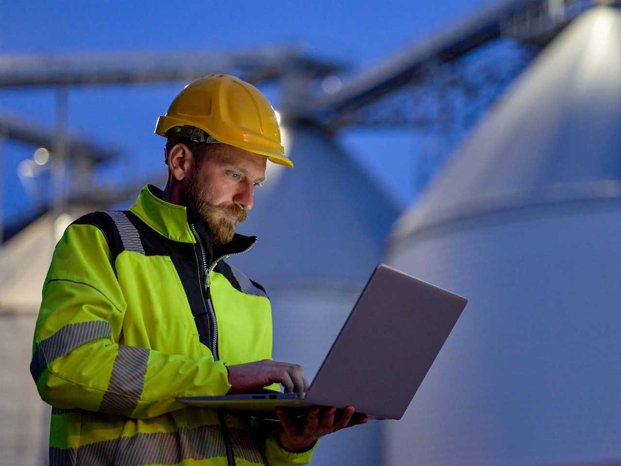 A worker using a laptop at a factory