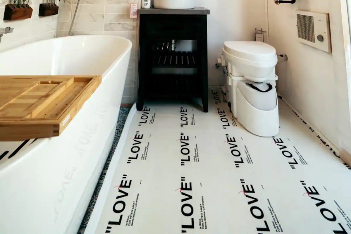 The bathroom in Ansel Troy's Airbnb with a bath and sink unit next to a toilet.