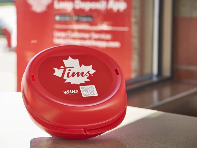 A red Tupperware container designed to hold a sandwich and fries from Tim Horton's