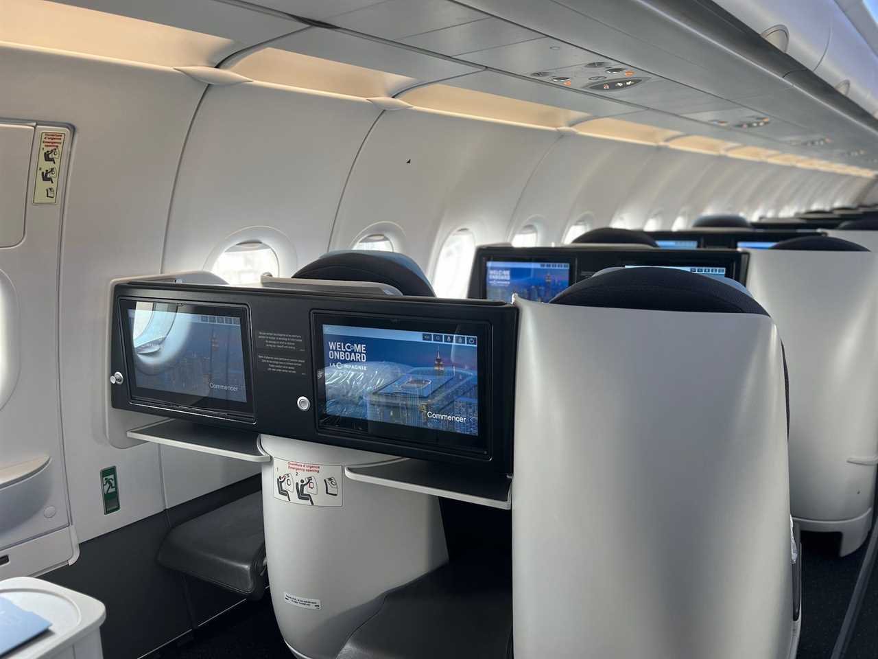 Flying on La Compagnie all-business class airline from Paris to New York — a view of the seatback screens.