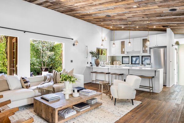 Inside, crisp white walls pop against the wooden ceilings and floors. An oversized breakfast bar and central island separates the kitchen from the main living room.