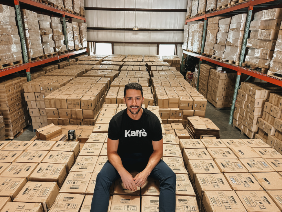 Kaffe founder Robert Gomez sits on boxes in a warehouse