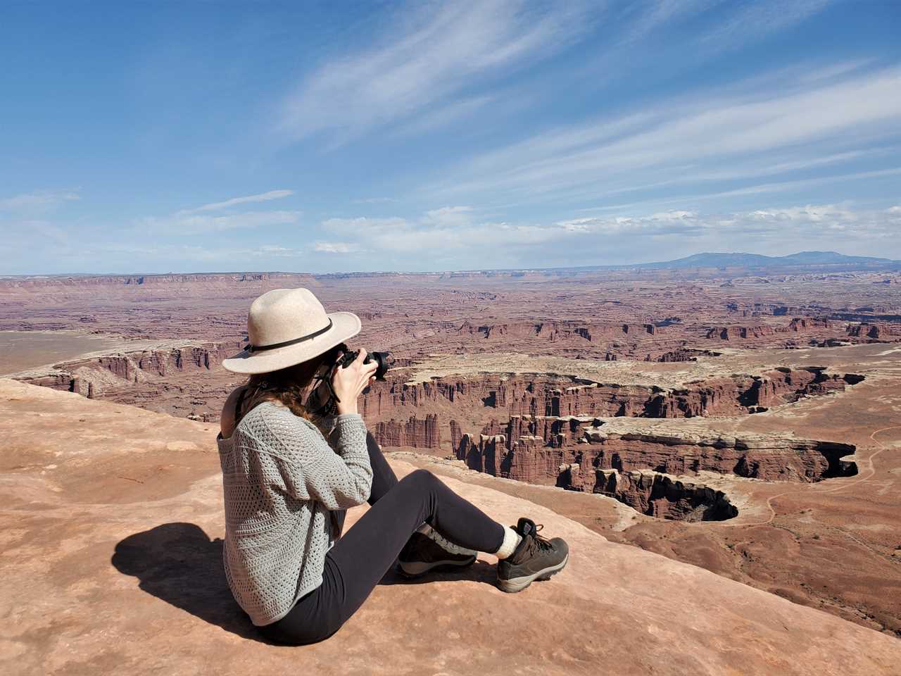 a woman taking a photo on a mountain