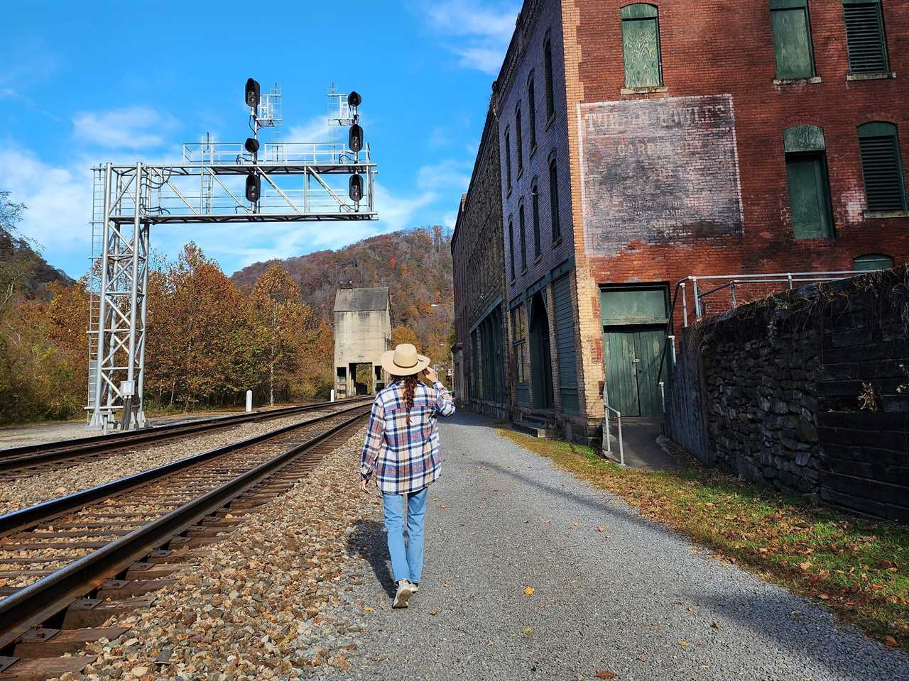 a woman walking next to a train track