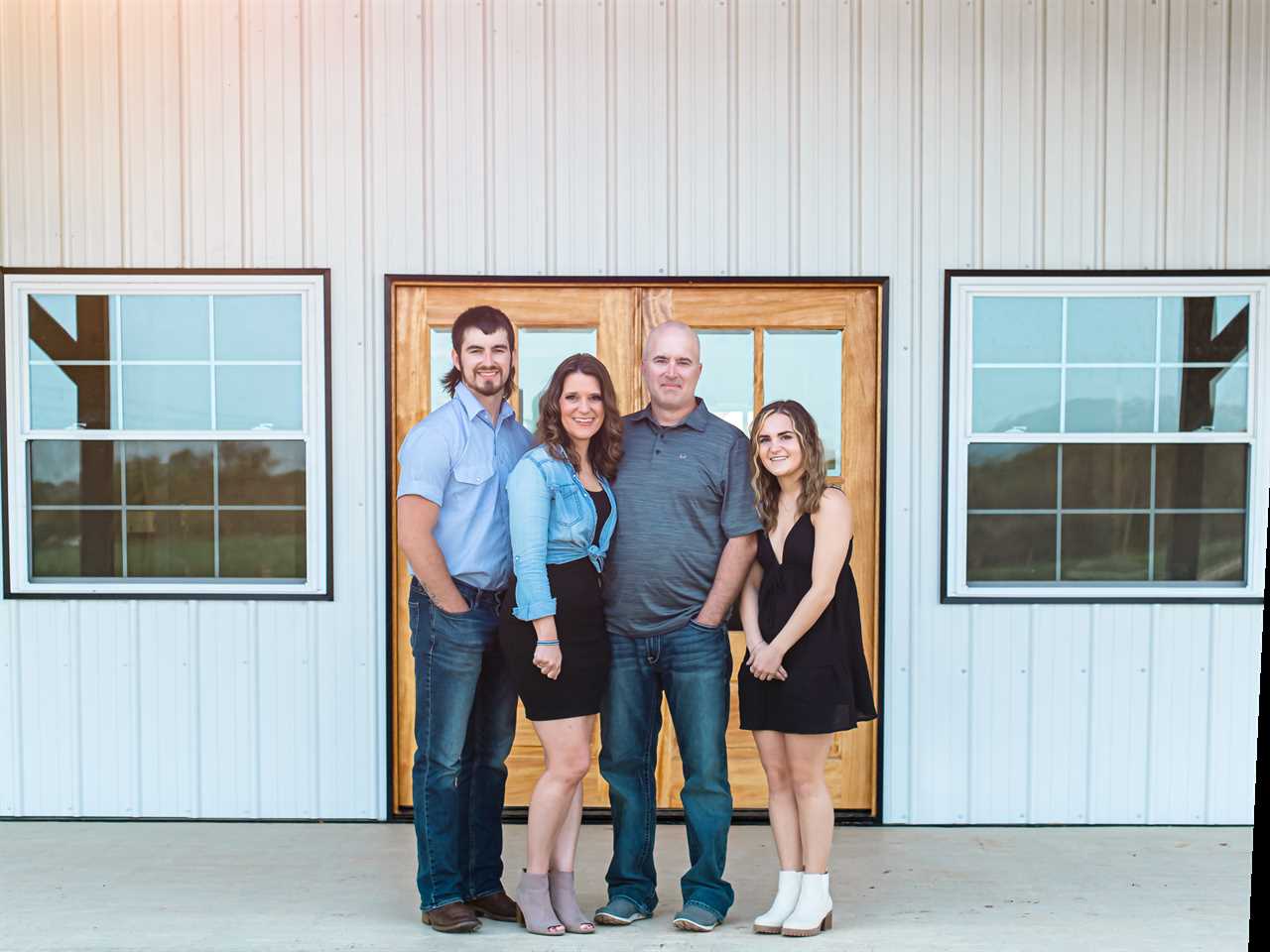 Angel and her family standing outside their barndominium.