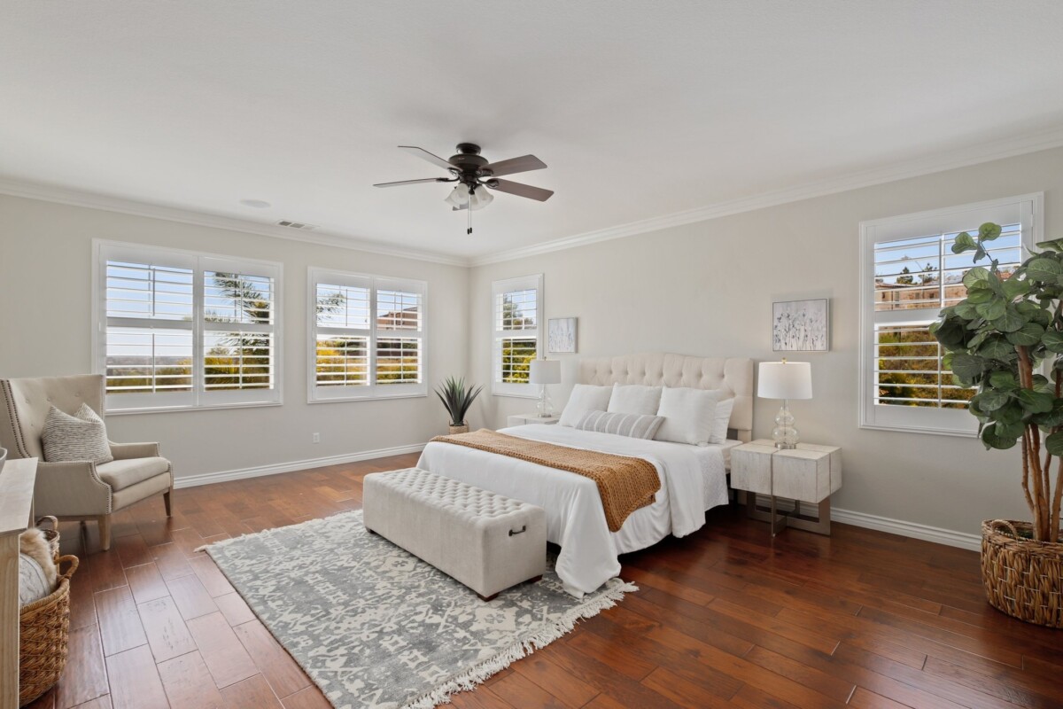 spacious primary bedroom with new blinds and hardwood floors