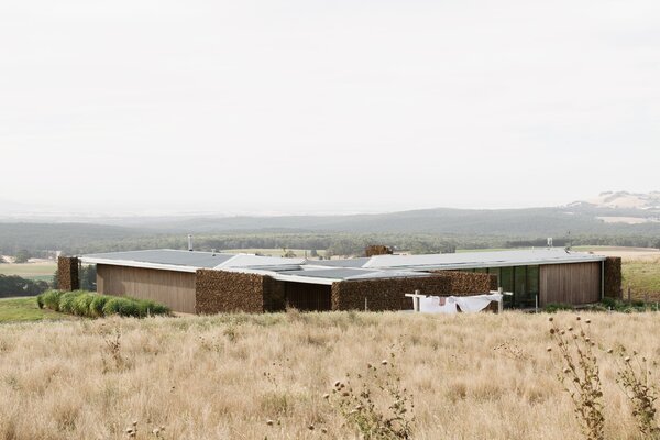 Gabion Walls Made of Volcanic Rock Flank a Flat-Roofed Farmhouse in Australia