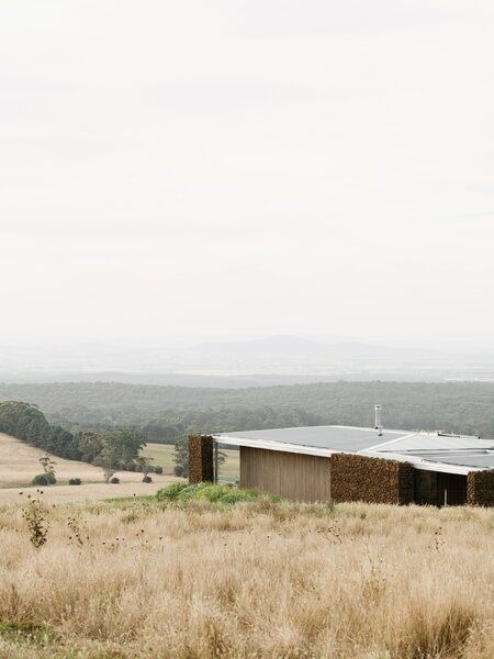 Gabion Walls Made of Volcanic Rock Flank a Flat-Roofed Farmhouse in Australia