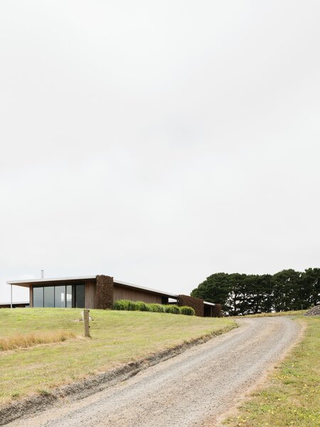 Gabion Walls Made of Volcanic Rock Flank a Flat-Roofed Farmhouse in Australia