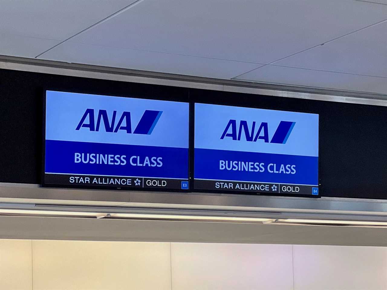 Two ANA business class signs at check-in.