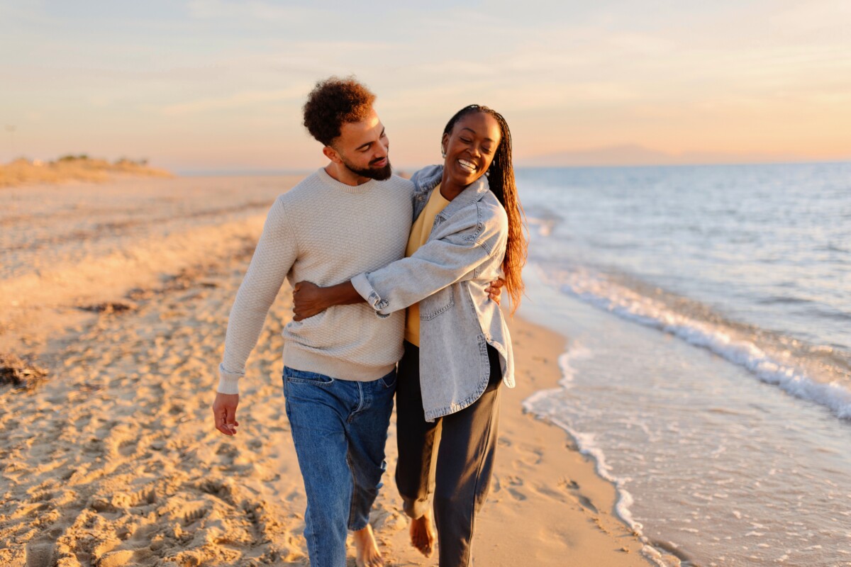 Couple walking on barefoot in the sand 