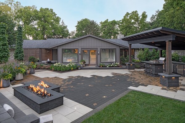 This home is elevated by the dramatic outdoor space, which uses large-scale Techo-Bloc Para tiles as a starting canvas. A scattering of Techo-Bloc Diamond pavers in colors that echo the home’s exterior palette create a dynamic abstract composition that connects the outdoor kitchen to the fire pit and stone bench.