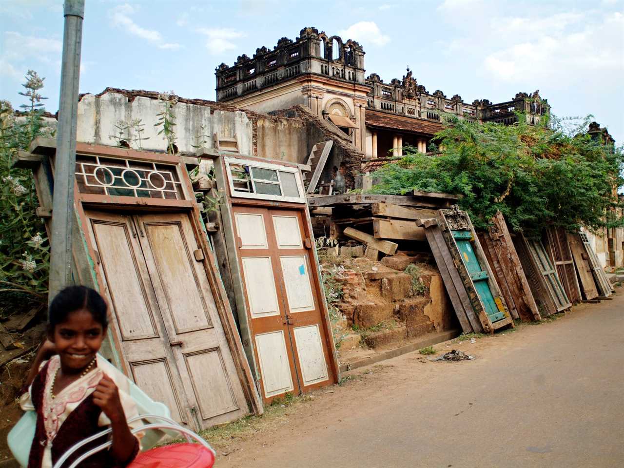 A village girl walks past an old Chettinad mansion, dismantled for the antique trade in Karaikudi, in the Chettinad region of Tamil Nadu in 2006.