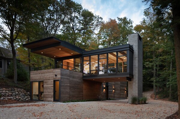 The house's many mature trees provide privacy from nearby neighbors, while the large canopy covers an extended outdoor deck.