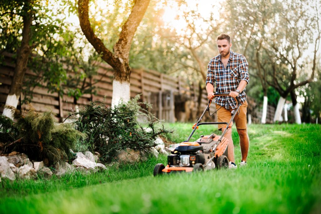 Man mowing around landscaping