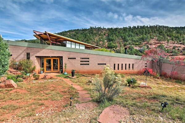 Capped with a soaring roofline, the home appears to be emerging from its desert setting.