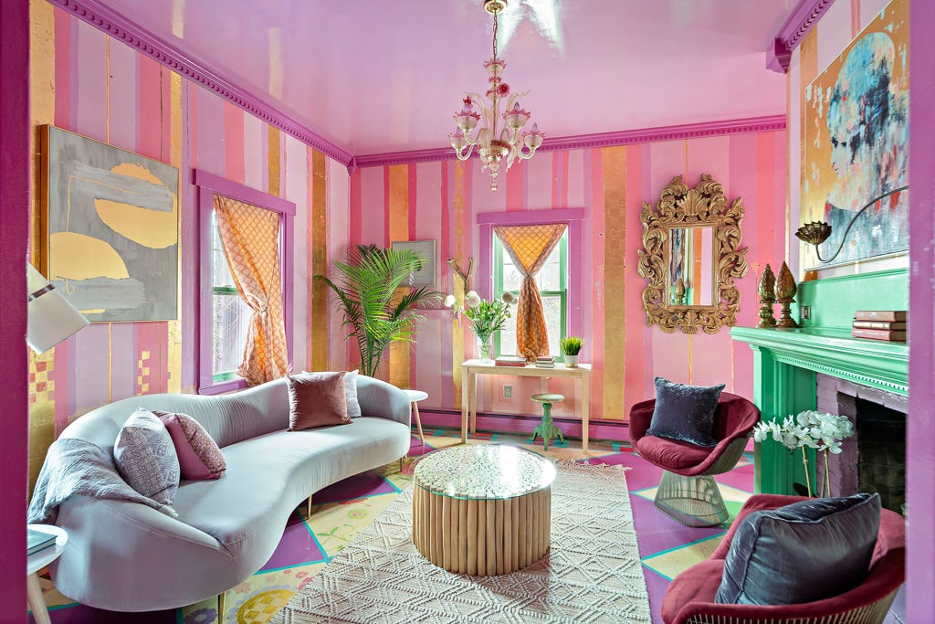 A living room with pink and gold wallpaper