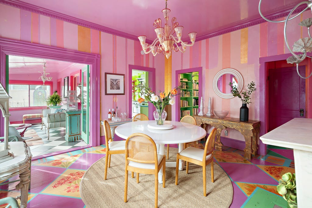 A dining room with pink and gold wallpaper