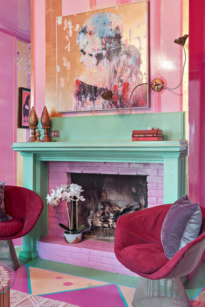 A teal fireplace with a colorful artwork above