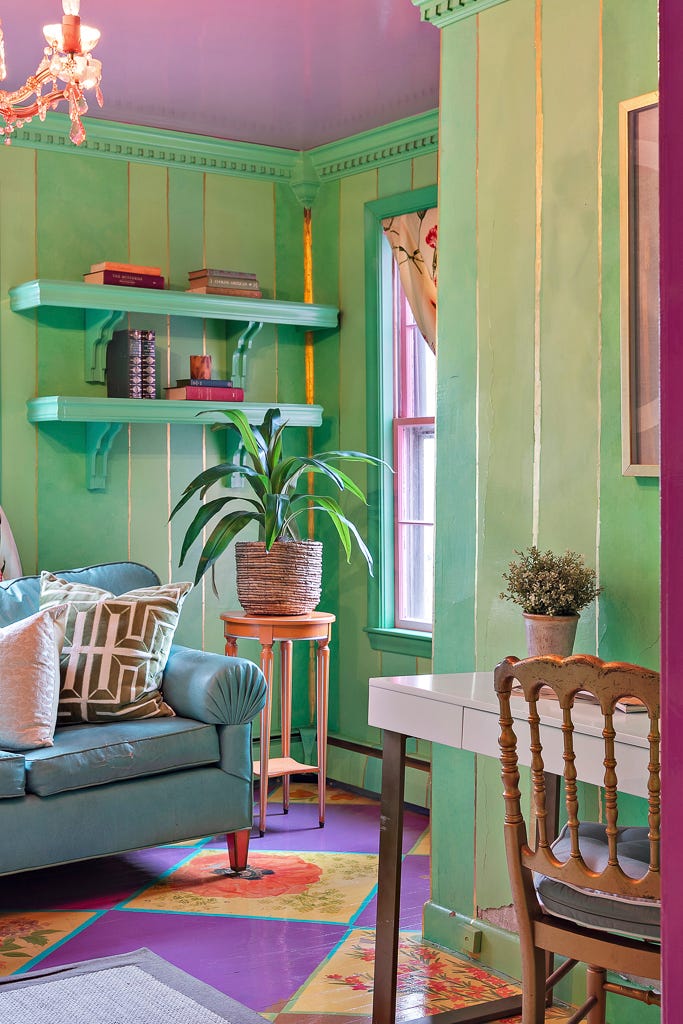 A green sitting room with flower patterned tiles