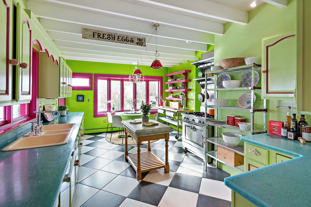 A lime green kitchen with black and white tiles and green cabinets