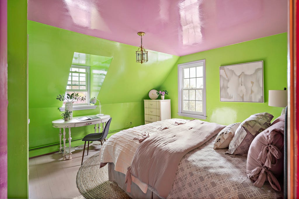 A bedroom with green walls and a glossy pink ceiling