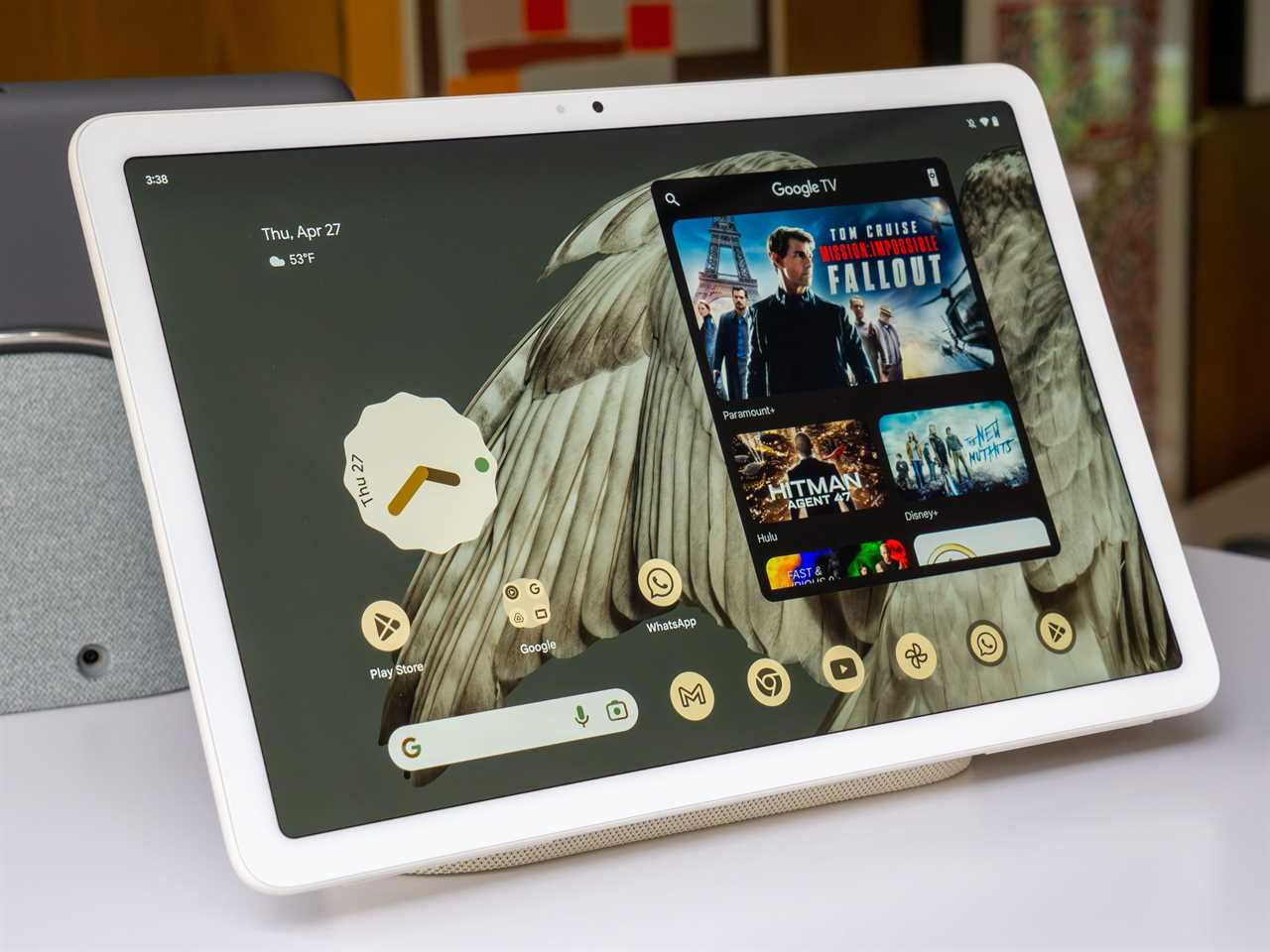 The Google Pixel Tablet set up on a counter displaying the home screen.