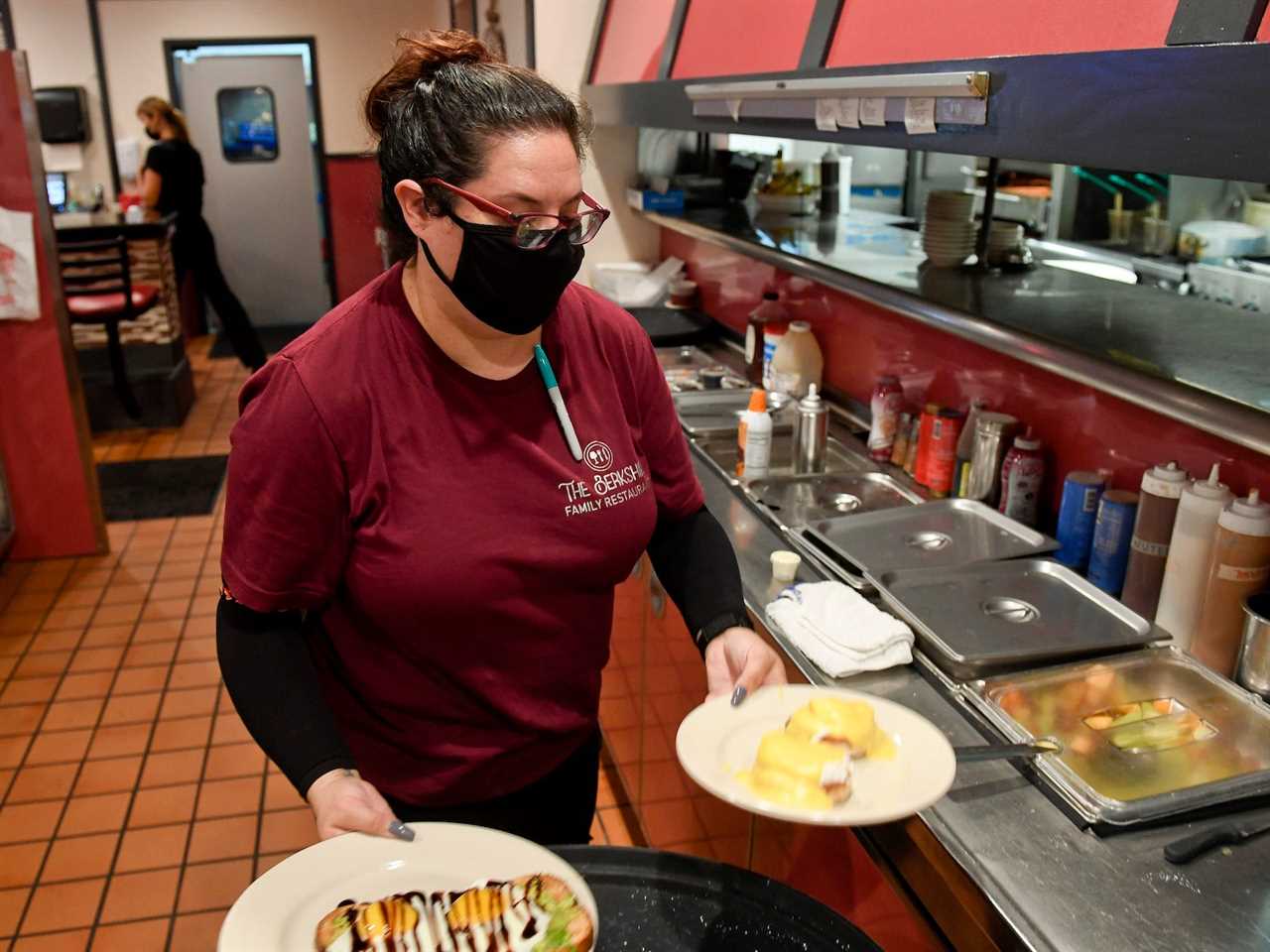 A manager of The Berkshire Family Restaurant is carrying plates with food