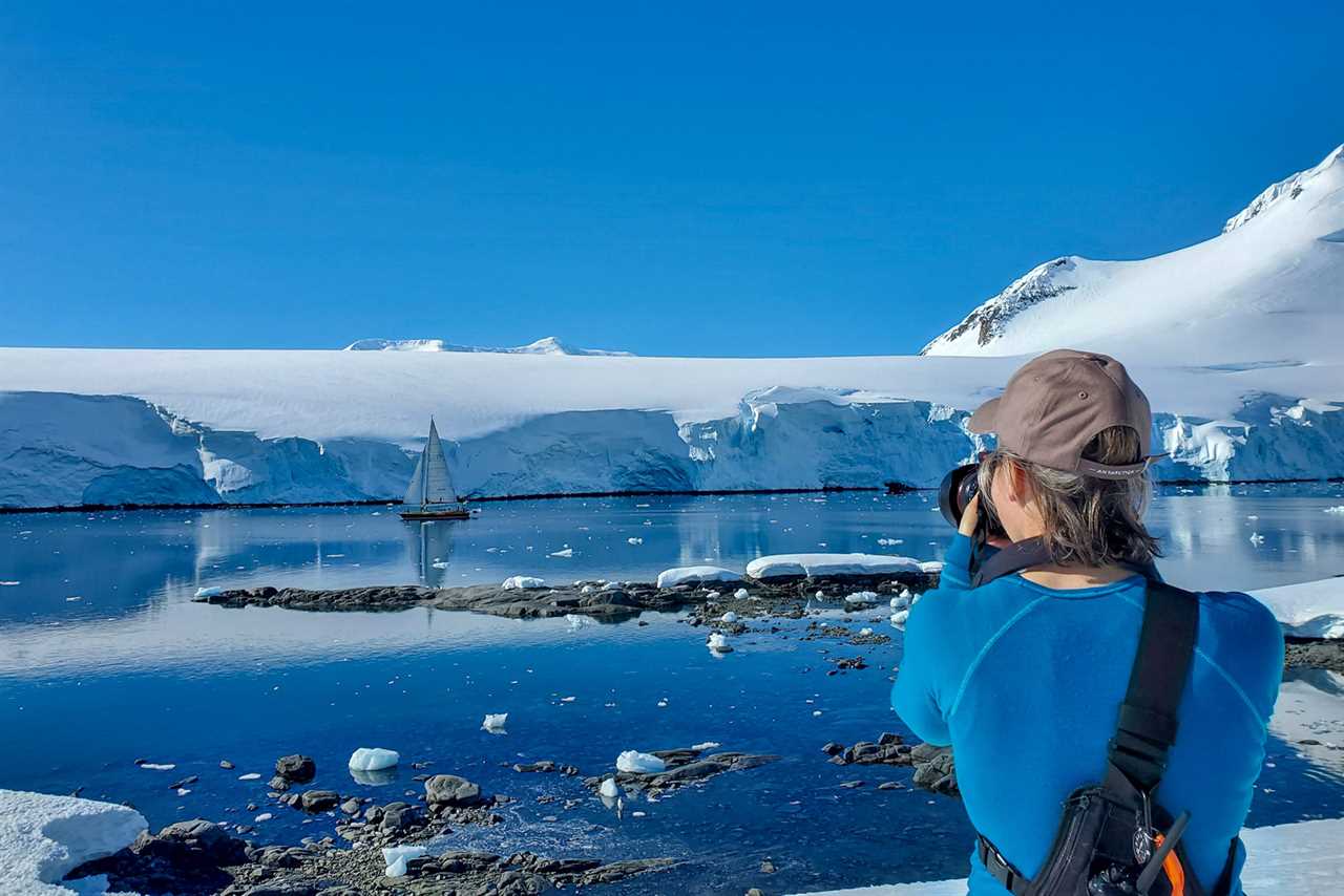 Lucy Bruzzone with her back turned away from the camera, taking a picture in Antarctica