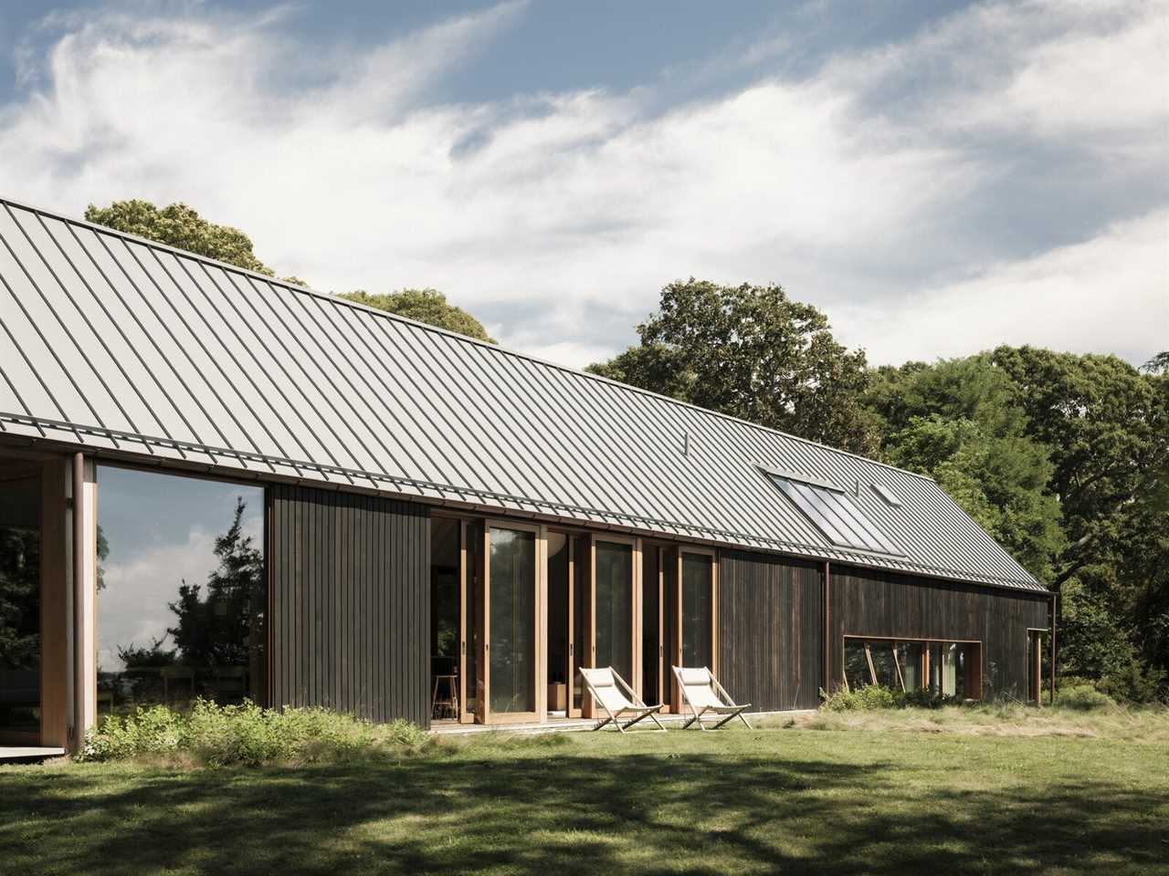 Lake|Flato designed a weekend home on North Fork, Long Island that nods to the rustic agricultural structures dotting the region. Western red cedar siding is stained black to help the home's three structures recede into the landscape.