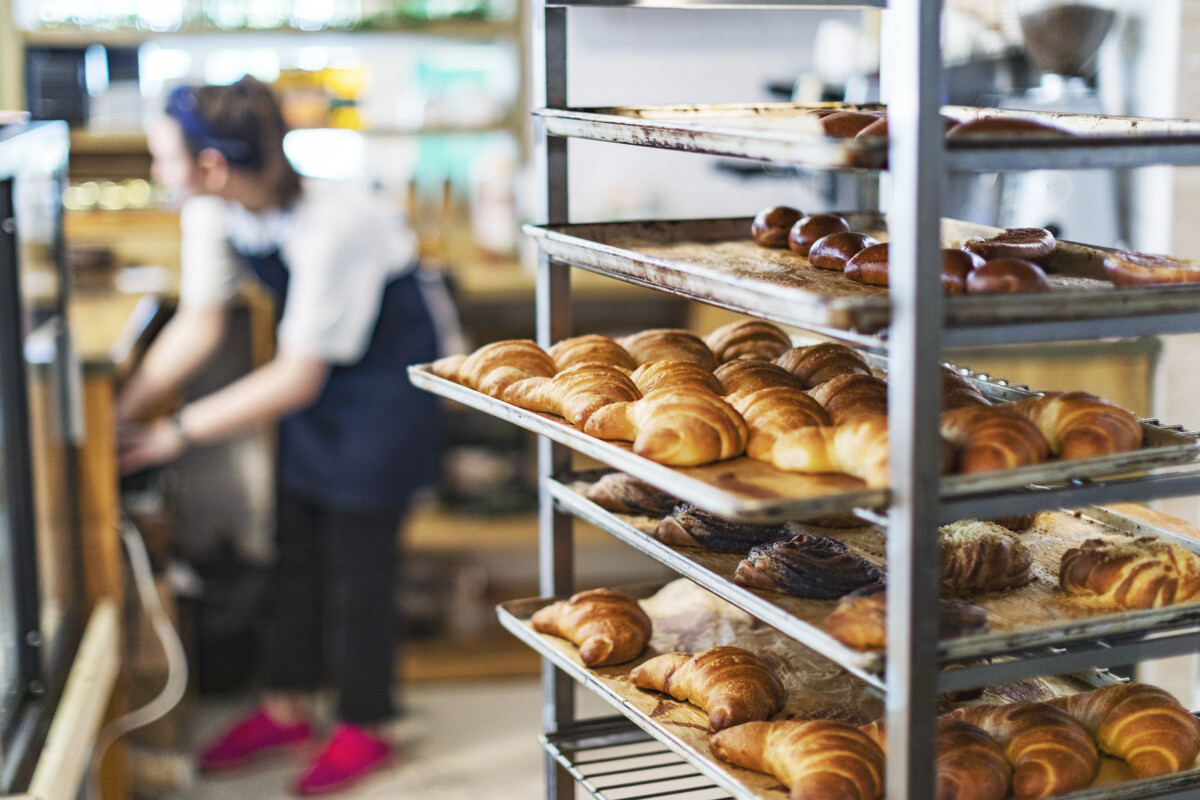 Fresh French Bread and croissants in a Bakery in cooling rack _ getty