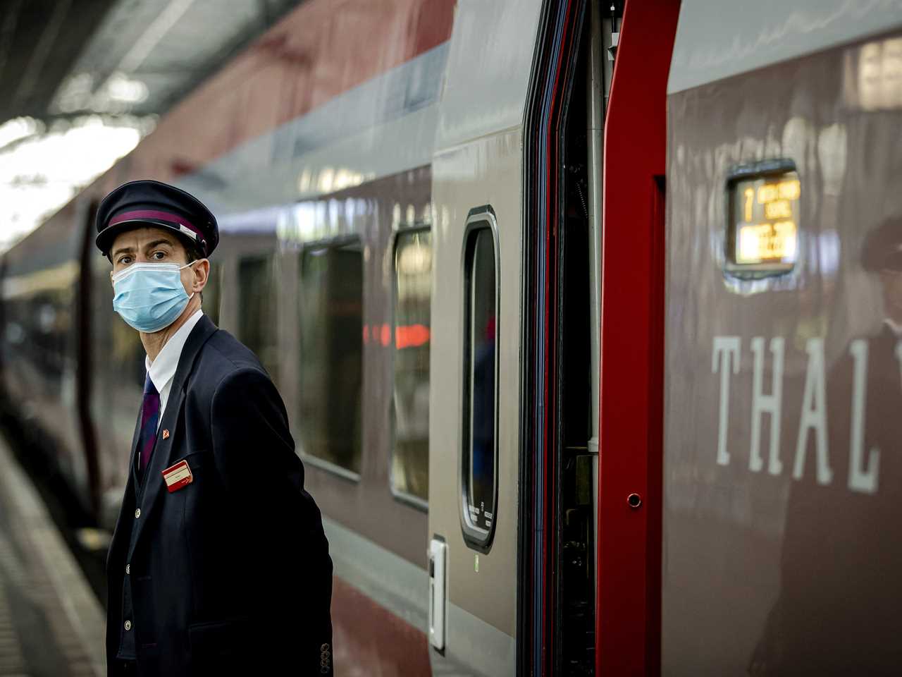 An inspector stands on the platform close to the revamped Thalys train carriage at Amsterdam Central railway station, on October 26, 2021.