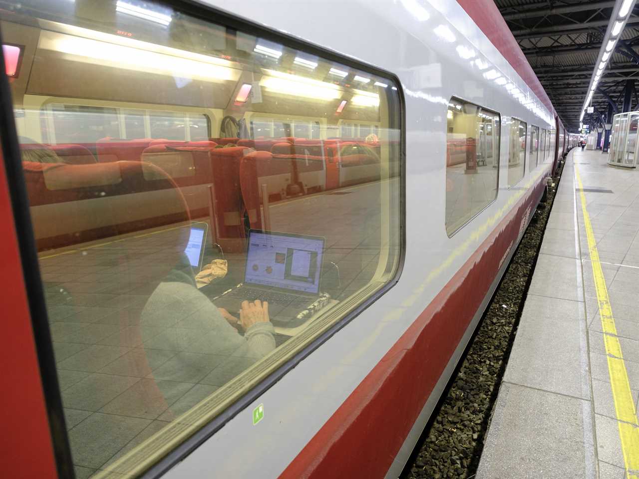 A woman working on her laptop in the economy section of a Thalys train.