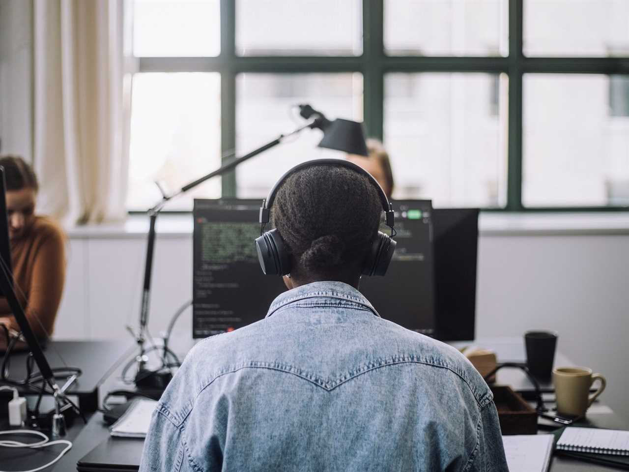 Computer programmer working on computer code in an office